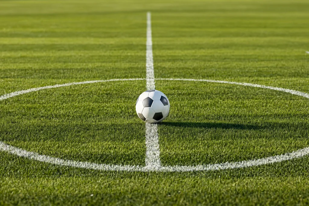 Mown grass stripes across the centre of an empty football pitch